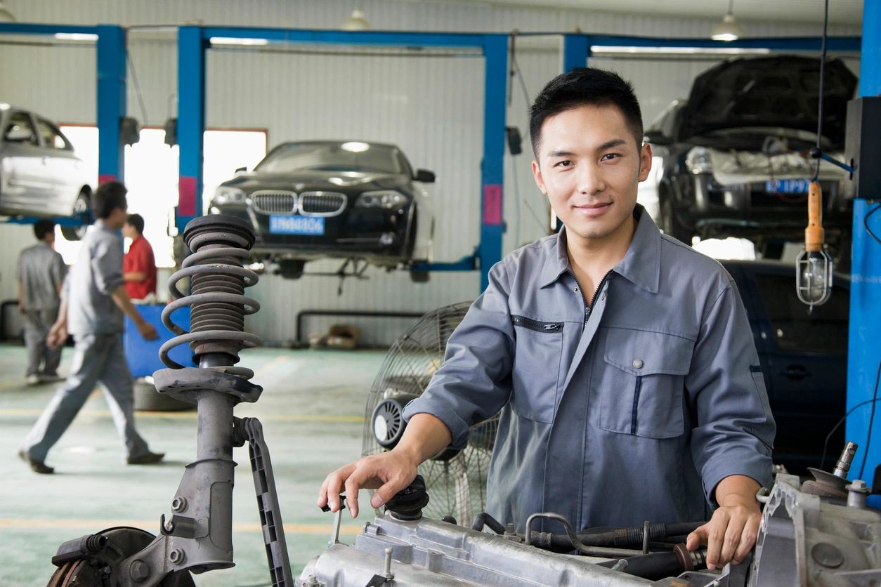 A man in blue shirt standing next to car.