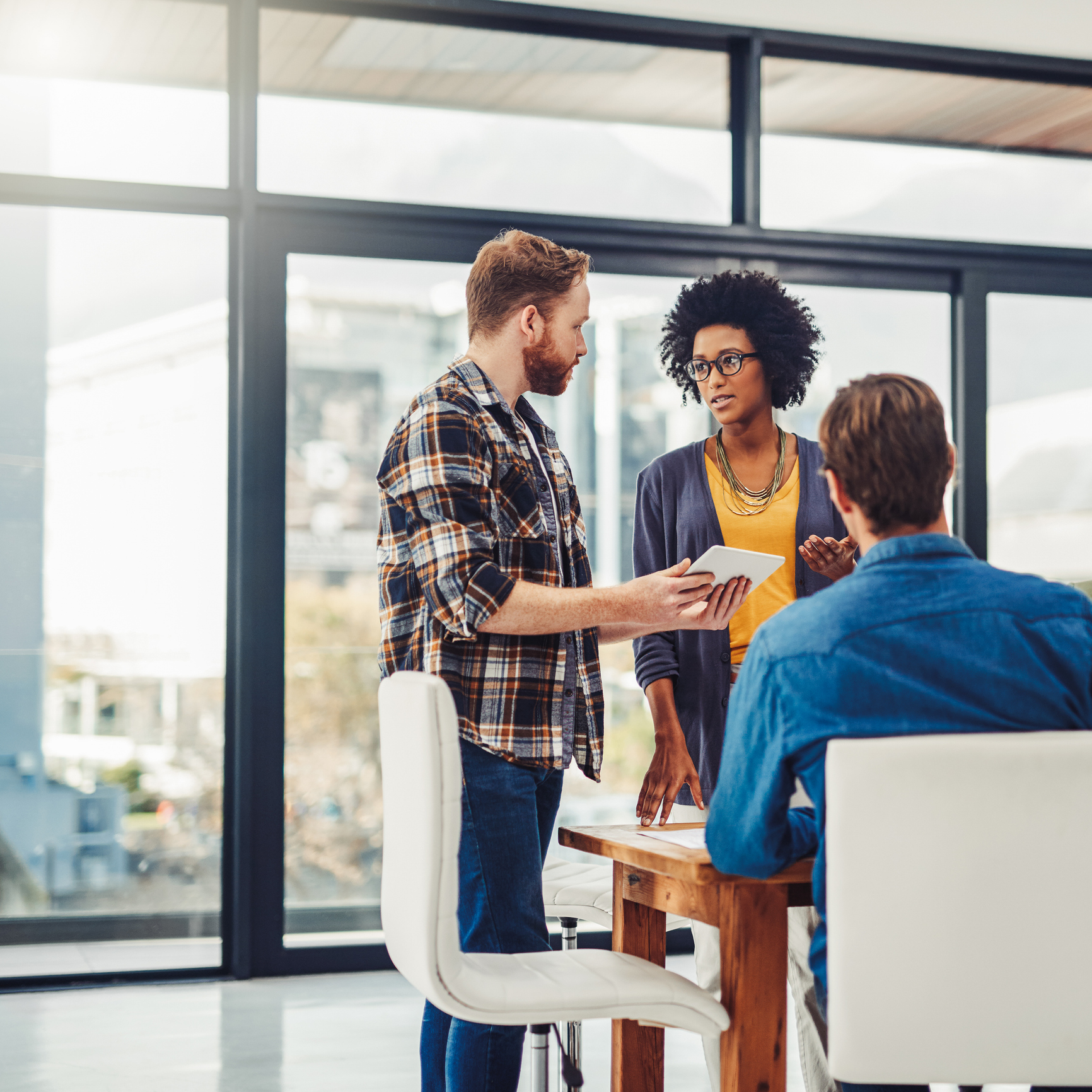 Colleagues discussing at a modern office table.