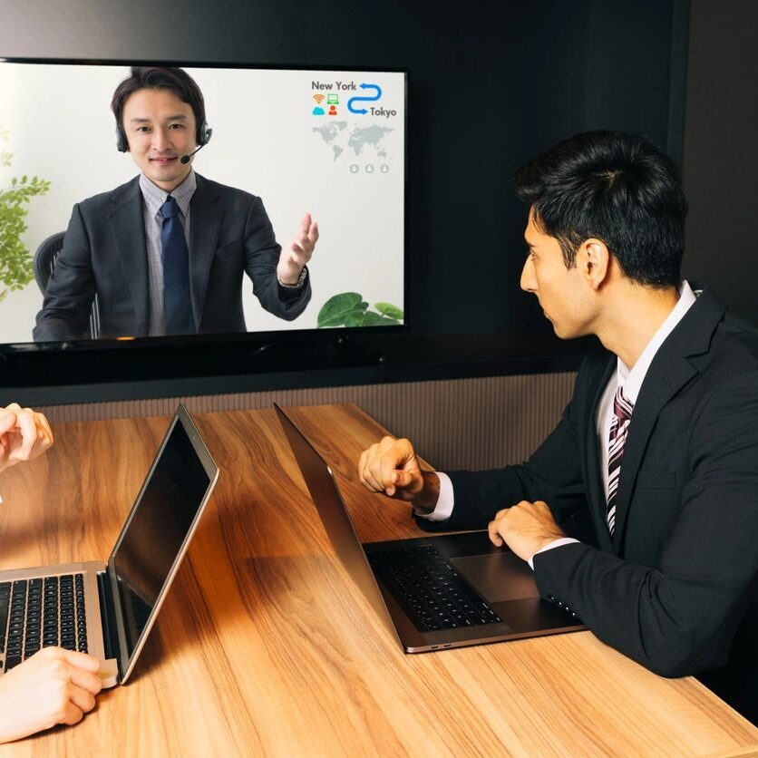 A man in a suit is on the computer screen